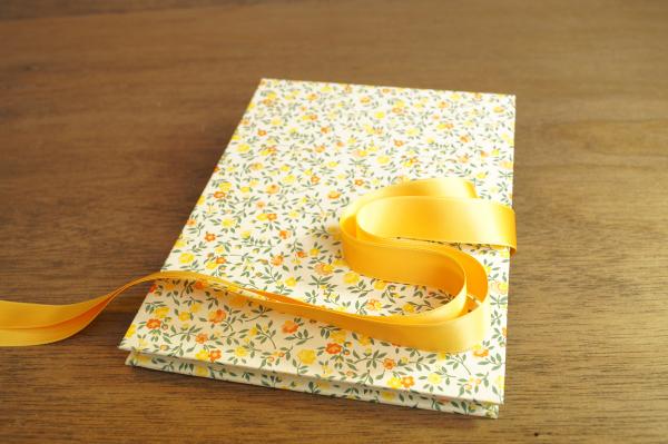 Leporello with scattered yellow flowers and a yellow bow